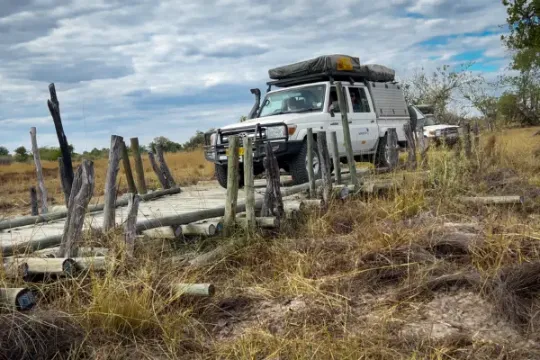 Samochód outventure.life przejeżdża przez most w rezerwacie Moremi, safari w Botswanie