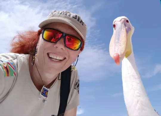 Anna Olej - Kobus nachylająca się nad fotografem, obok niej pelikan.